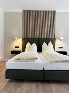 巴特洪内夫Weingut Pieper - Vinothek & Hotel am Drachenfels的卧室内的两张床,配有白色床单和枕头