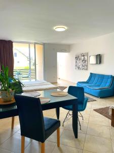 帕利克SOBE AVA的客厅配有蓝色的沙发、桌子和椅子