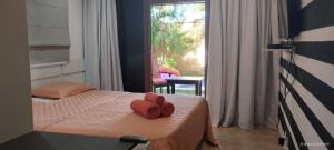 皮帕Casa incrivel piscina privada e jacuzzi Villa Deluxe Pipa Spa Beleza Resort的一间卧室配有一张带红色毛巾的床