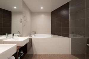 二世古清水酒店的白色的浴室设有2个盥洗盆和淋浴。
