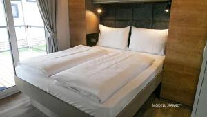 圣卡尼兹Camping Breznik的一张配有白色床单和枕头的大床