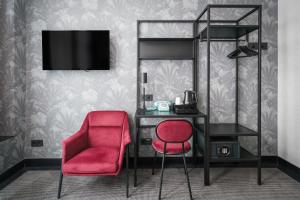 阿姆斯特丹Krisotel的一间卧室配有书桌和红色椅子