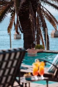 伊丽莎白港Courtyard Hotel Gqeberha的棕榈树旁游泳池里的男人