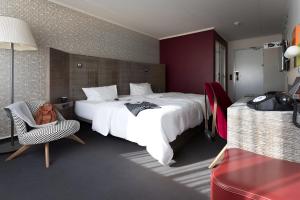 维也纳pentahotel Vienna的酒店客房带一张大床和一把椅子