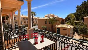 阿尔布费拉Bicos J by Check-in Portugal的阳台上的两瓶红色的酒坐在长凳上