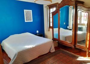 蒙得维的亚Apartamento de estilo en edificio patrimonial的蓝色的客房配有床和镜子