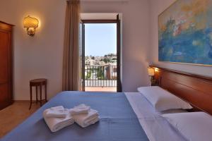利帕里Hotel Villa Cute - HVC的一间卧室配有一张大床和毛巾