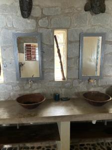 Nosy KombaNosy Komba Lodge的石质浴室设有2个水槽和2个镜子