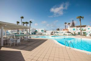 卡勒达德福斯特Smy Tahona Fuerteventura的毗邻度假酒店的带桌椅的游泳池