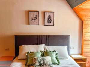 泰斯Logu i Harushave的卧室配有一张墙上三幅照片的床