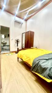 Hoàng NgàCat homestay的一间卧室配有黄色的床和镜子