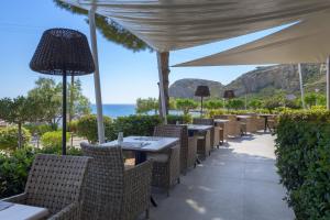 阿彻奇洛斯波尔图埃格里酒店的一个带桌椅的户外用餐区,享有海景。