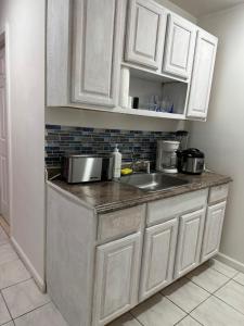 泽西市Pipo’s perfect place的厨房配有白色橱柜和水槽