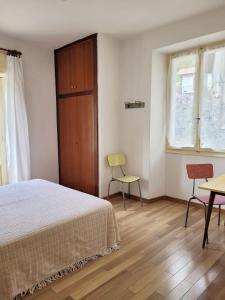 加尔达湖滨Hotel Panorama的卧室配有一张床和一张桌子及椅子