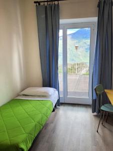 加尔达湖滨Hotel Panorama的卧室在窗户前设有一张绿色的床