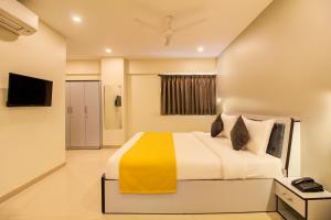 浦那Housemate Hotel的一间卧室配有一张带黄色毯子的大床