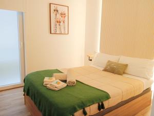 阿利坎特Annamaria B&B Alicante Centro的小卧室配有一张带绿毯的床