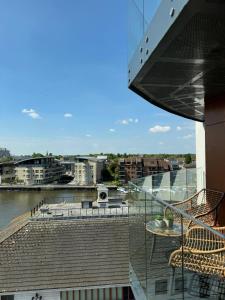 伦敦Entire Kingston Two bedroom Apartment Town centre & River view, 32 minutes to London Waterloo Station的享有河流和建筑景致的阳台