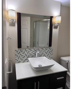卡尔加里Calgary-Banff single house close LRT&UC&Free Parking的浴室设有白色水槽和镜子