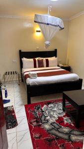 内罗毕White Star Hotel的一间卧室配有一张红色地毯的大床