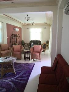 Qaryat Shurūqساحل الشمالي قريه امون的客厅配有沙发、椅子和桌子
