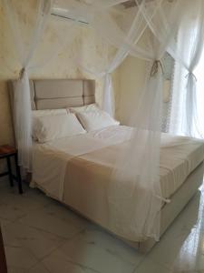 Villaggio TedeschiLa Casa的卧室配有白色的床、窗帘和窗户