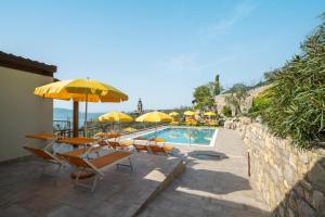 加尔尼亚诺Residence Dany appartamenti con cucina vista lago piscina e parcheggio的一个带桌椅和遮阳伞的游泳池