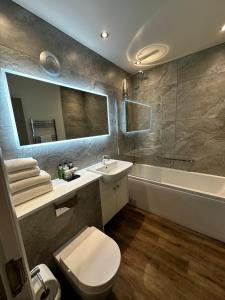 伊辛沃尔德The George Hotel Easingwold的浴室配有卫生间、盥洗盆和浴缸。