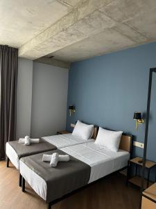 第比利斯Hotel Citizen Avlabari的卧室设有两张床铺和蓝色的墙壁