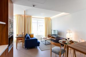 里斯本Oscar Concept Apartments的客厅配有蓝色的沙发和蓝色的椅子
