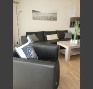 库克斯港Quartier Hohe Geest 17 - Nord Seestern - a69854的客厅配有黑色沙发和桌子