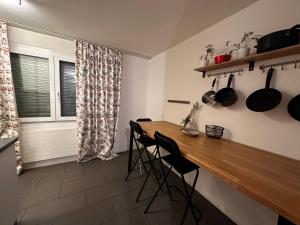苏黎世Spacious apartment的厨房配有木桌、椅子和窗户。