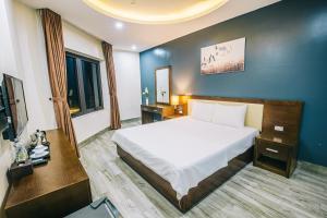 岑山Hệ Thống Sen Biển Hotel FLC Sầm Sơn - Restaurant Luxury的酒店客房,配有床和电视
