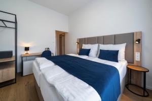 布拉格Hotel LEON的一间卧室配有一张带蓝白色床单的大床