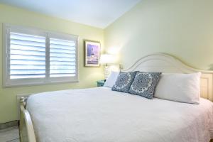 基拉戈Kona Kai Resort and Gallery的卧室配有白色的床和窗户。
