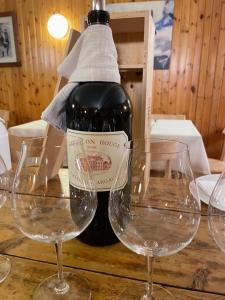 马代西莫艾尔伯格K2酒店的一张桌子上摆放着一瓶葡萄酒和两杯酒杯