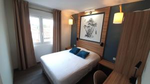 拉沃尔Logis Hôtel - Les Pasteliers的小卧室配有带蓝色枕头的床