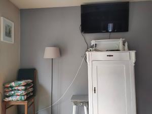弗罗茨瓦夫弗罗茨瓦夫马洛夫公寓的一间白色橱柜顶部配有电视的房间