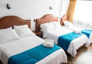 莱瓦镇HOTEL ENCANTO COLONIAL的酒店客房设有两张床和窗户。