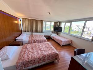 伊斯坦布尔Hotel Nayla的一间酒店客房,设有三张床和一台平面电视