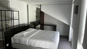 里斯本Oscar Concept Apartments的卧室配有白色的床和镜子