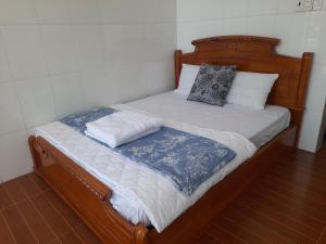 Trung AnNGỌC LINH MT的一张木制床,上面有两个枕头