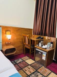 喀布尔Khyber Hotel的客房设有书桌、桌子和床。