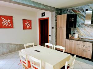 萨莱马拉西诺Kidonia - Iseo Lake Apartmens的一间厨房,里面配有白色的桌子和椅子