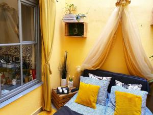 克拉科夫Edem room的一间卧室设有一张黄色墙壁和窗户的床