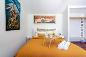 维埃拉·多米尼奥Gerês Escape Retreat - Casa da Fonte de Pedra的一间卧室配有一张带橙色床罩的床