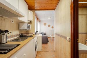 巴尔巴特Apartamento playa del Carmen的厨房配有水槽和炉灶 顶部烤箱