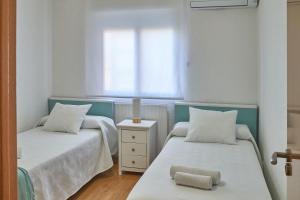 托莱多Lux Buenavista的客房设有两张床和窗户。