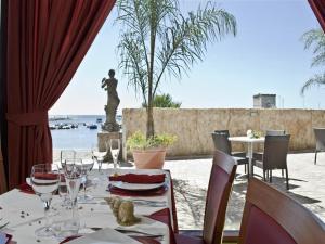 托雷拉皮罗Hotel Alba的酒杯桌子和背景雕像