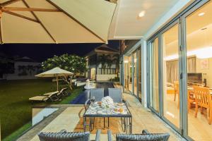 岘港Ocean Beach Resort Da Nang的庭院配有桌椅和遮阳伞。